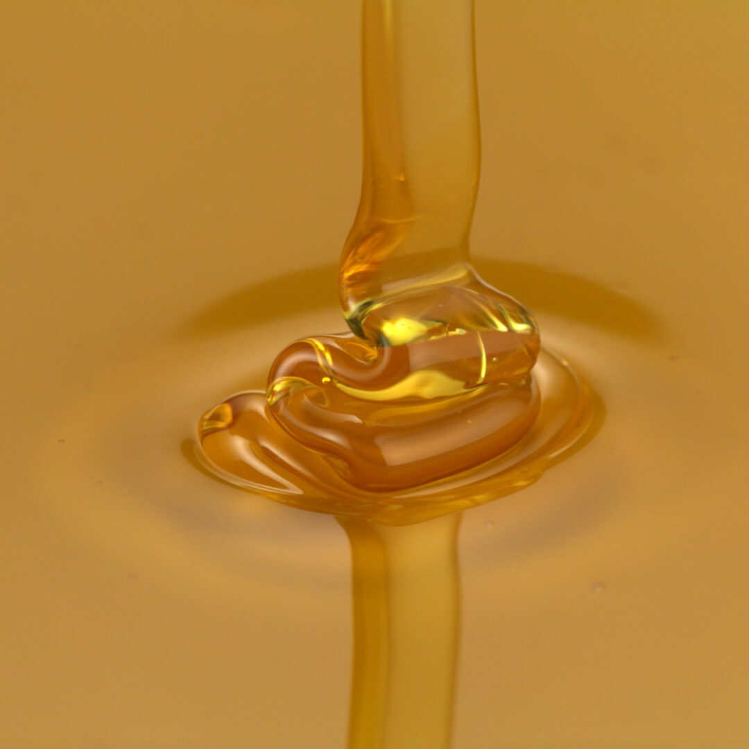 Mel sendo derramado em um favo de mel.