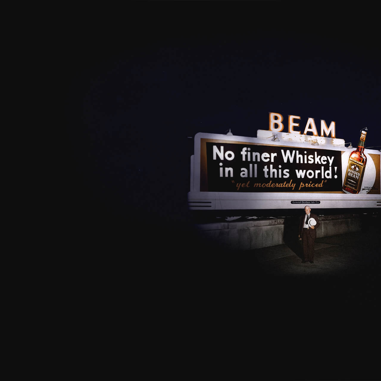 James B. Beam standing in front of a billboard.