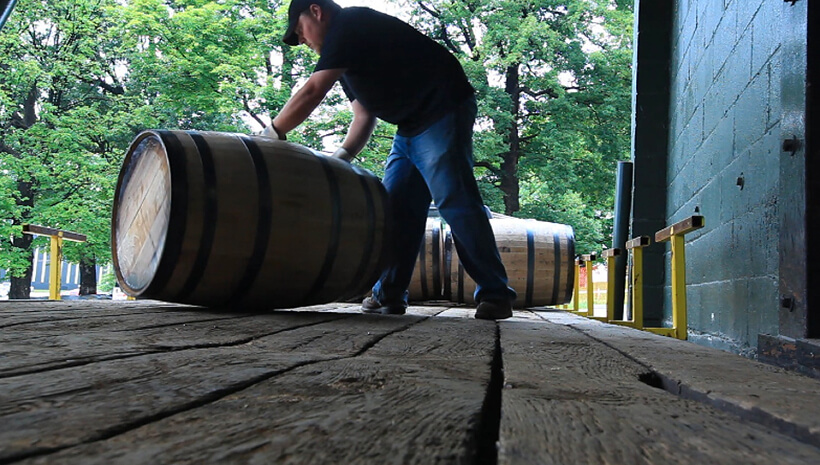 Um trabalhador da Jim Beam American Stillhouse rola um barril.