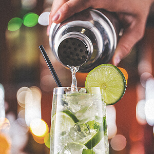 A bartender fills a glass with a delicious Jim Beam bourbon drink.